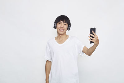 Portrait of smiling man standing against white background