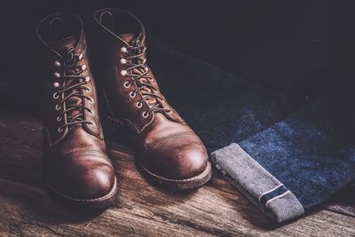 Close-up of leather shoes with jeans on wooden floor