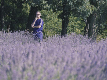 Woman standing on purple flower on field