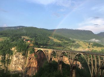 Bridge over river against cloudy sky