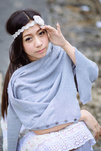 Portrait of beautiful woman standing against water