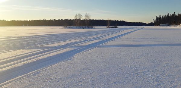 Snow covered field against sky