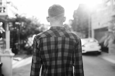 Rear view of man standing on street in city