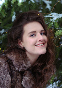 Portrait of a smiling young woman against trees