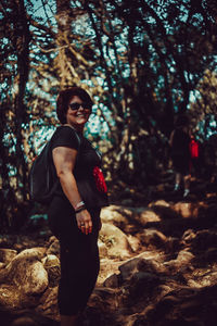 Side view of young woman standing on rock