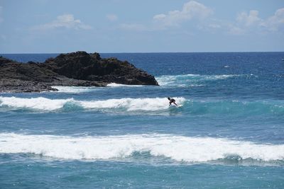 Man surfing in sea against sky