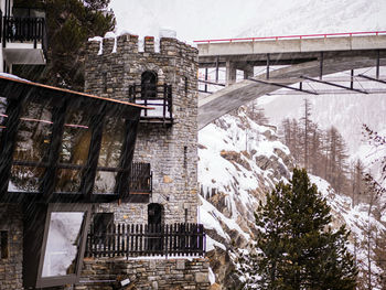 Bridge by buildings in city during winter