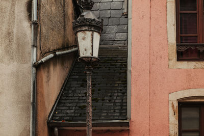 Low angle view of electric lamp on wall of old building