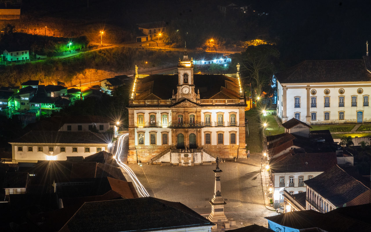 HIGH ANGLE VIEW OF ILLUMINATED CITY BUILDINGS AT NIGHT