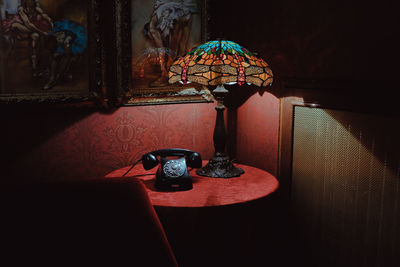 Close-up of illuminated electric lamp on table at home