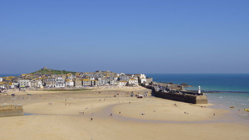 Scenic view of beach against clear blue sky