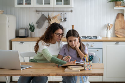 Portrait of young woman using laptop at home