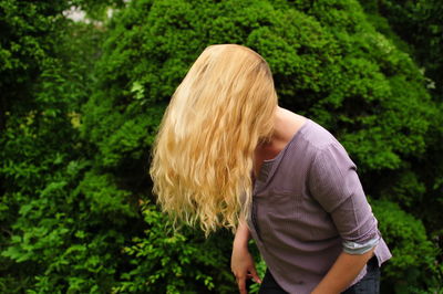 Woman covering face with long blond hair