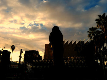 Silhouette of cemetery against sky during sunset