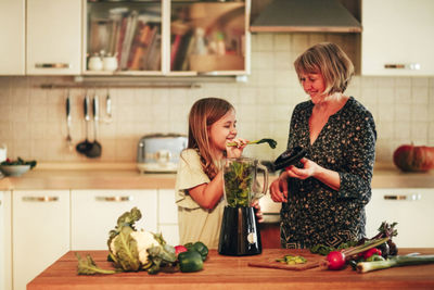 Grandmother and granddaughter preparing food at home