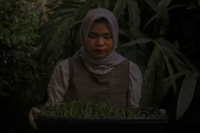 Portrait of senior man standing against plants