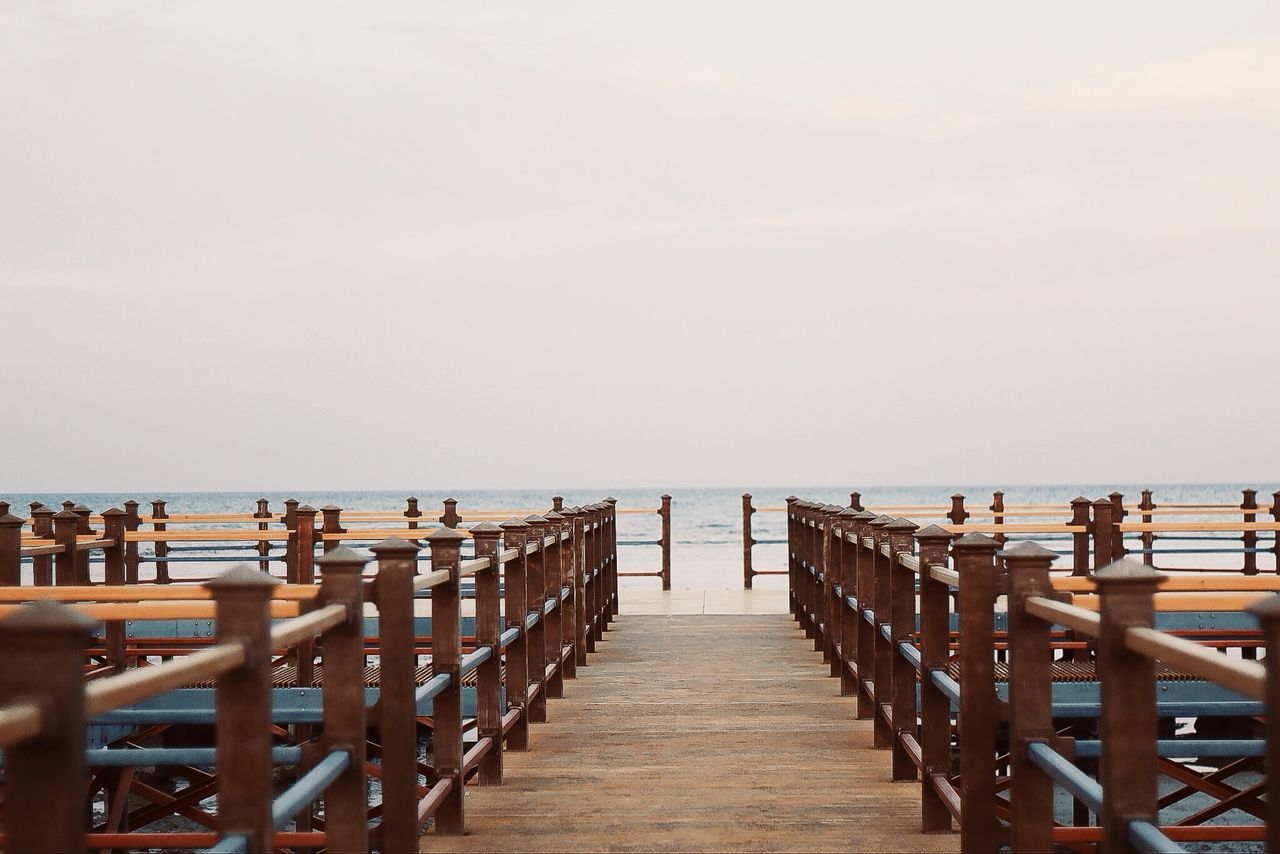 sea, water, horizon over water, pier, railing, beach, tranquil scene, scenics, tranquility, the way forward, copy space, clear sky, nature, beauty in nature, sky, boardwalk, vacations, large group of people, wood - material