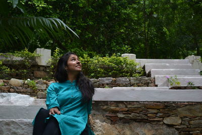 Thoughtful woman sitting on steps at public park