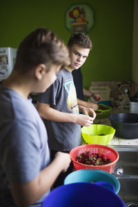 Two young men preparing food in kitchen
