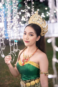 Portrait of young woman holding christmas tree