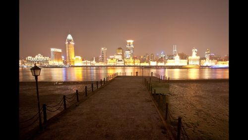 Illuminated bridge over river at night