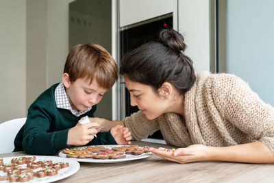 Mother and son preparing cookie at home