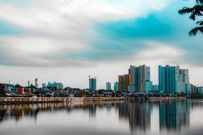 River by buildings against sky in city