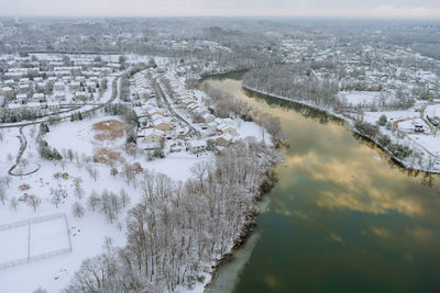 High angle view of river amidst buildings during winter