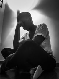 Woman sitting on bed at home