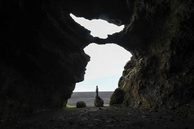 Rock formation on beach against sky