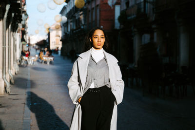 Portrait of woman standing on street in city