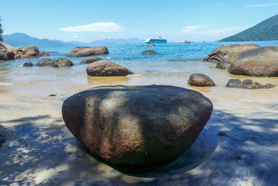 Rocks on beach against sky