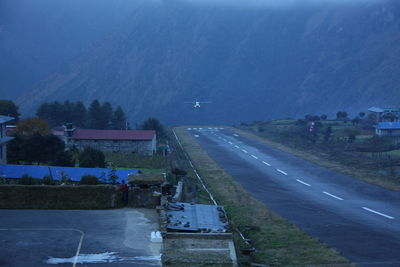 High angle view of airplane flying over road against sky