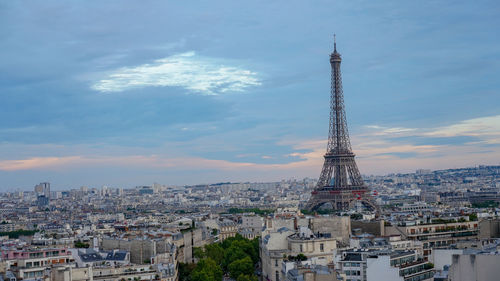 Aerial view of buildings in city against cloudy sky