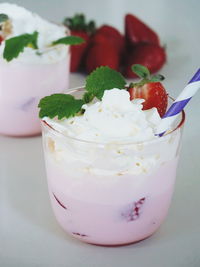 Strawberry milkshake with whipped cream in glass