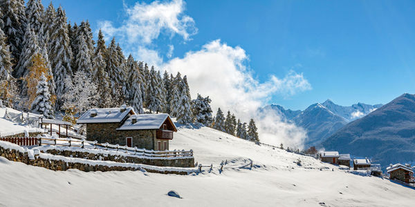 Houses on snow covered landscape against sky