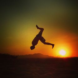 Full length of man jumping at sunset