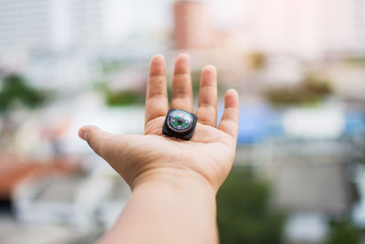 Close-up of hand holding navigational compass