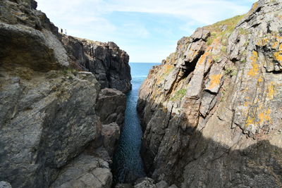 Rock formations by sea against sky