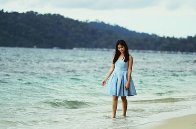 Portrait of young woman standing on beach