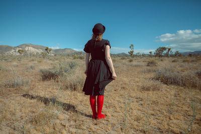 Rear view of woman standing on field