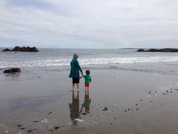 Portrait of mother with son standing at beach