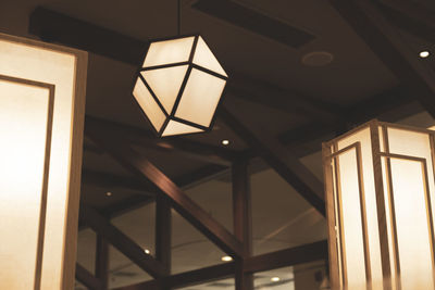 Low angle view of illuminated pendant lights hanging on ceiling