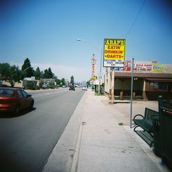 Information sign on road against sky