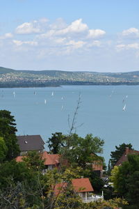 Houses by sea against sky