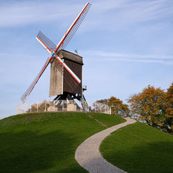 Traditional windmill on field against sky