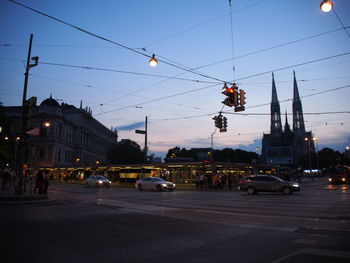 Cars on city street at sunset