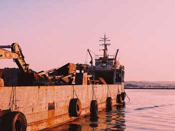 Ship in sea against clear sky during sunset