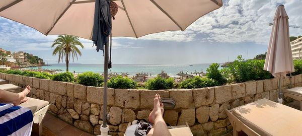 Man by swimming pool by sea against sky