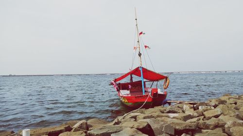 Sailboat on beach against clear sky